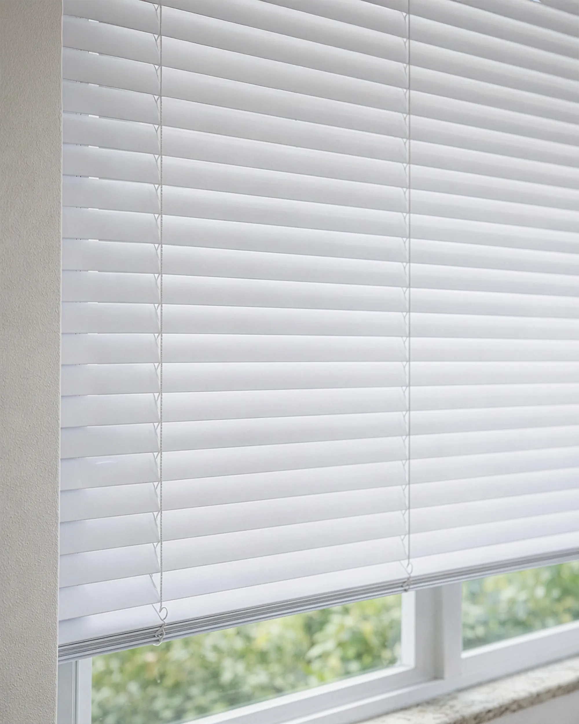 Persiana horizontal de alumínio branca com lâminas de 50mm instalada em ambiente interno, controlando a entrada de luz