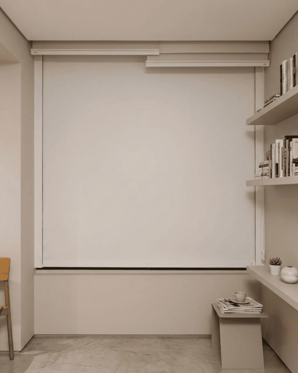 Persiana Rolô Blackout Box Branca com tecido Pinpoint instalada em home office com guias laterais e vedação completa.
