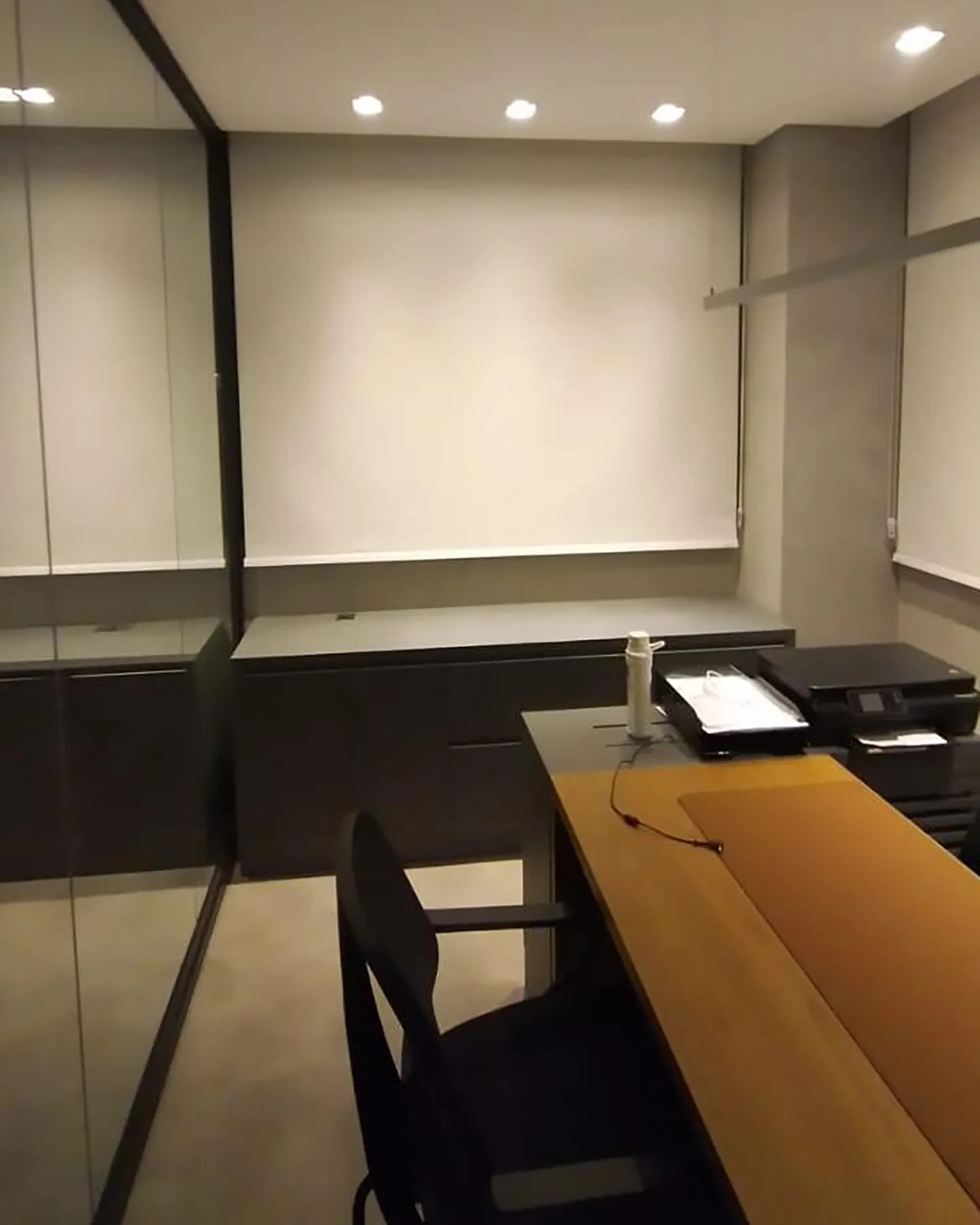 Persiana rolô tela solar 1% branca em home office com conforto visual e controle de luz.