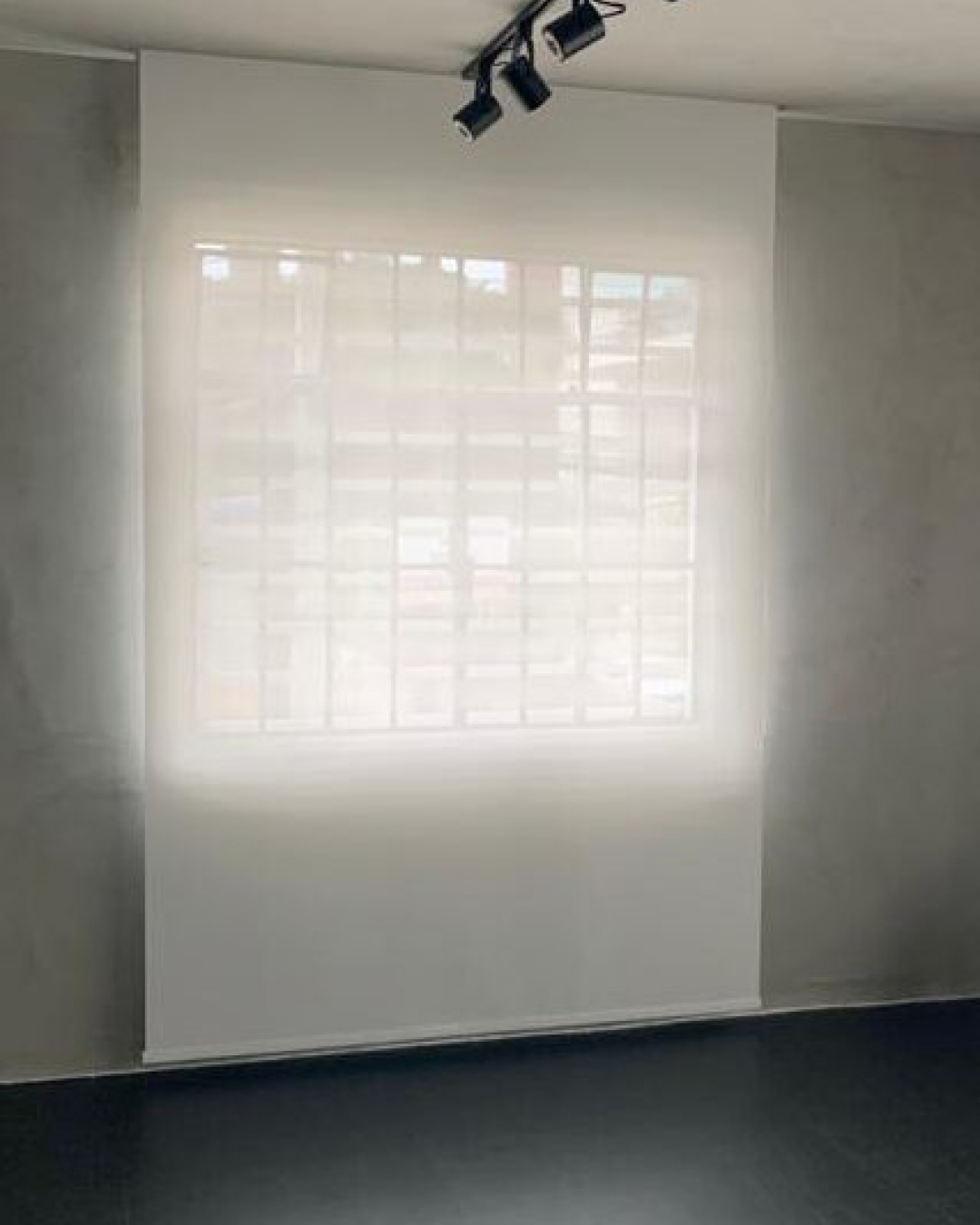 Persiana Rolô Tela Solar 5% Branca instalada em estúdio, controlando a luminosidade e reduzindo o ofuscamento.
