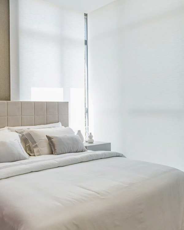 Persiana Rolô Translúcida Nápoles Branca instalada em quarto moderno com iluminação natural suave.
