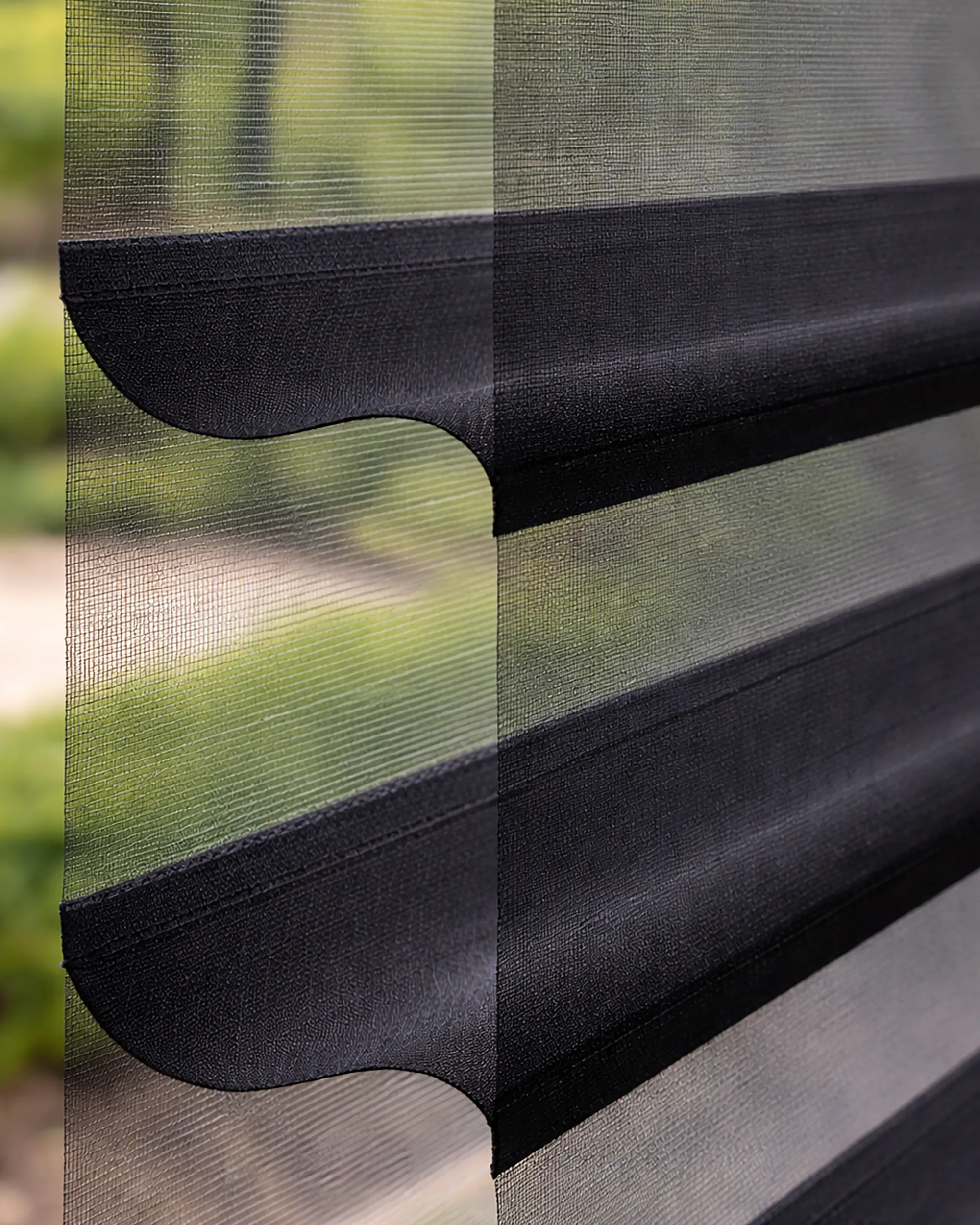 Tecido da persiana miragem preta com faixas alternadas translúcidas e opacas, permitindo controle de luz e privacidade no ambiente